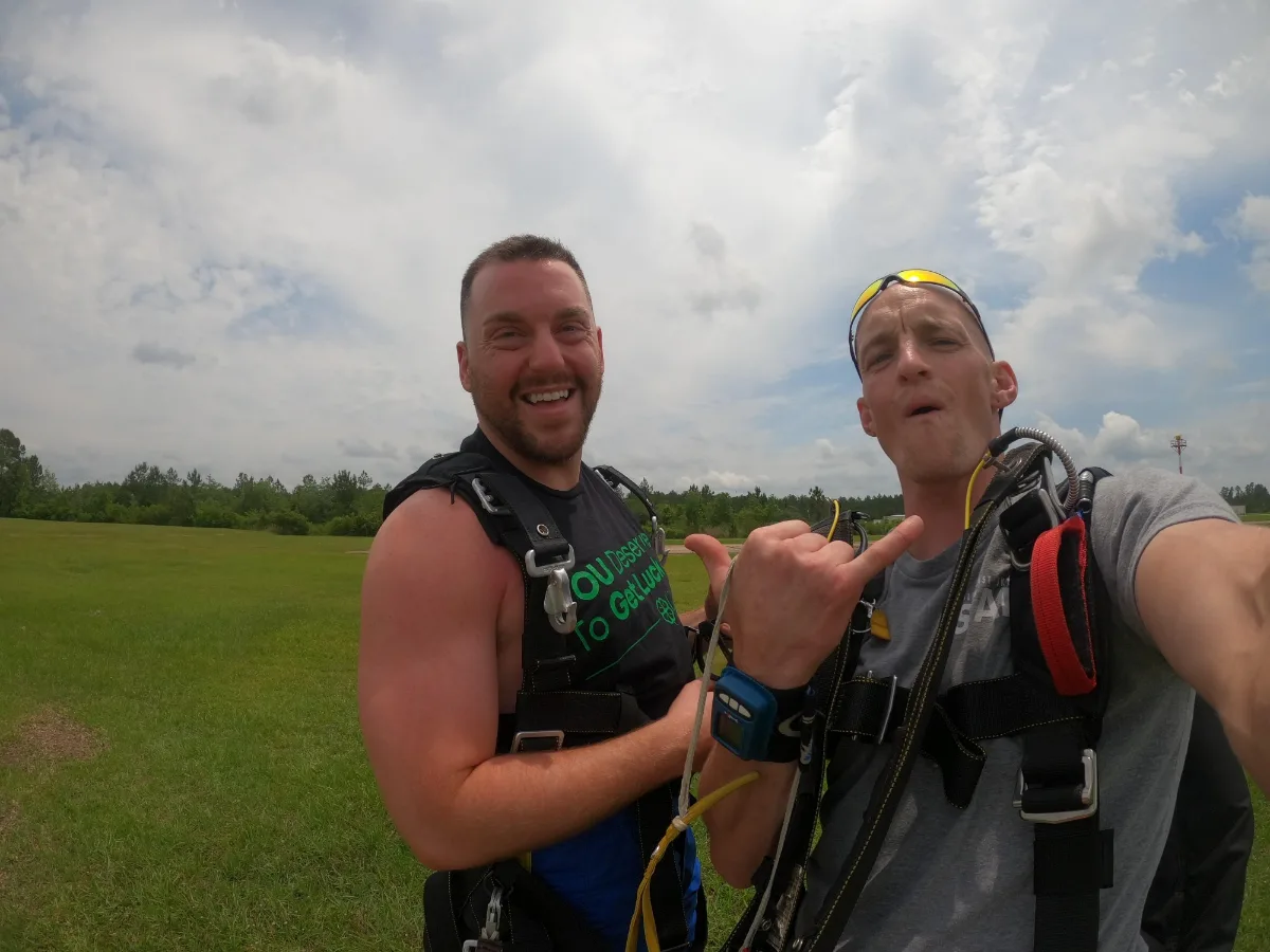 Tandem student and instructor celebrating on the landing field